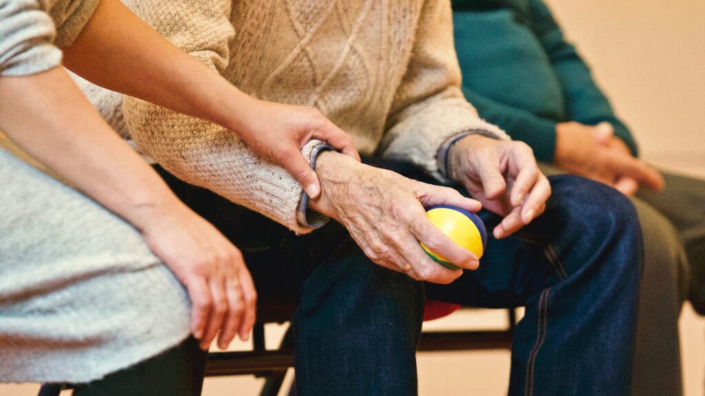 Older male holding foam ball for hand exercises