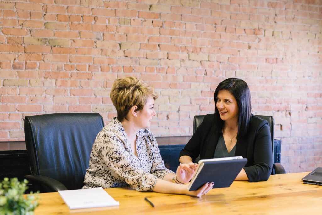 Two women sitting at a table in an office