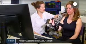 Woman using mechanical arm for stroke rehabilitation
