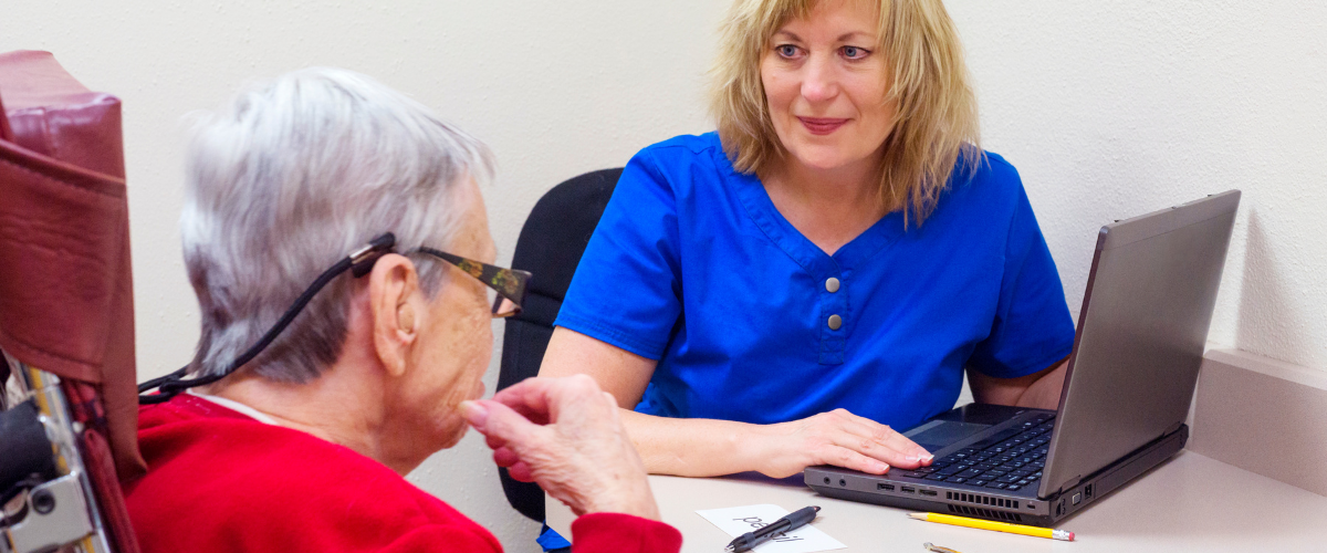 Lady in speech therapy with stroke survivor elderly woman